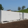 Illustration Credit: Wikipedia Creative Commons License. A large battery storage power station with a capacity of 6.24 MWh and an output of 5 megawatts (Tesvolt TPS-E).   Source: Rheineck, Author: Kecko from Eastern Switzerland